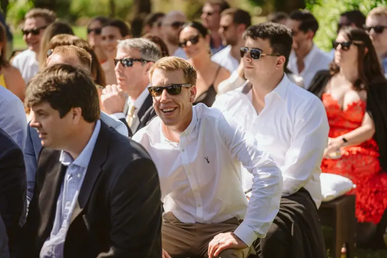 Guests in sunglasses smiling in the rows before the ceremony
