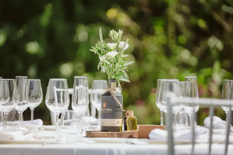 Table setting with wine glasses, olive oil and a vase of white flowers