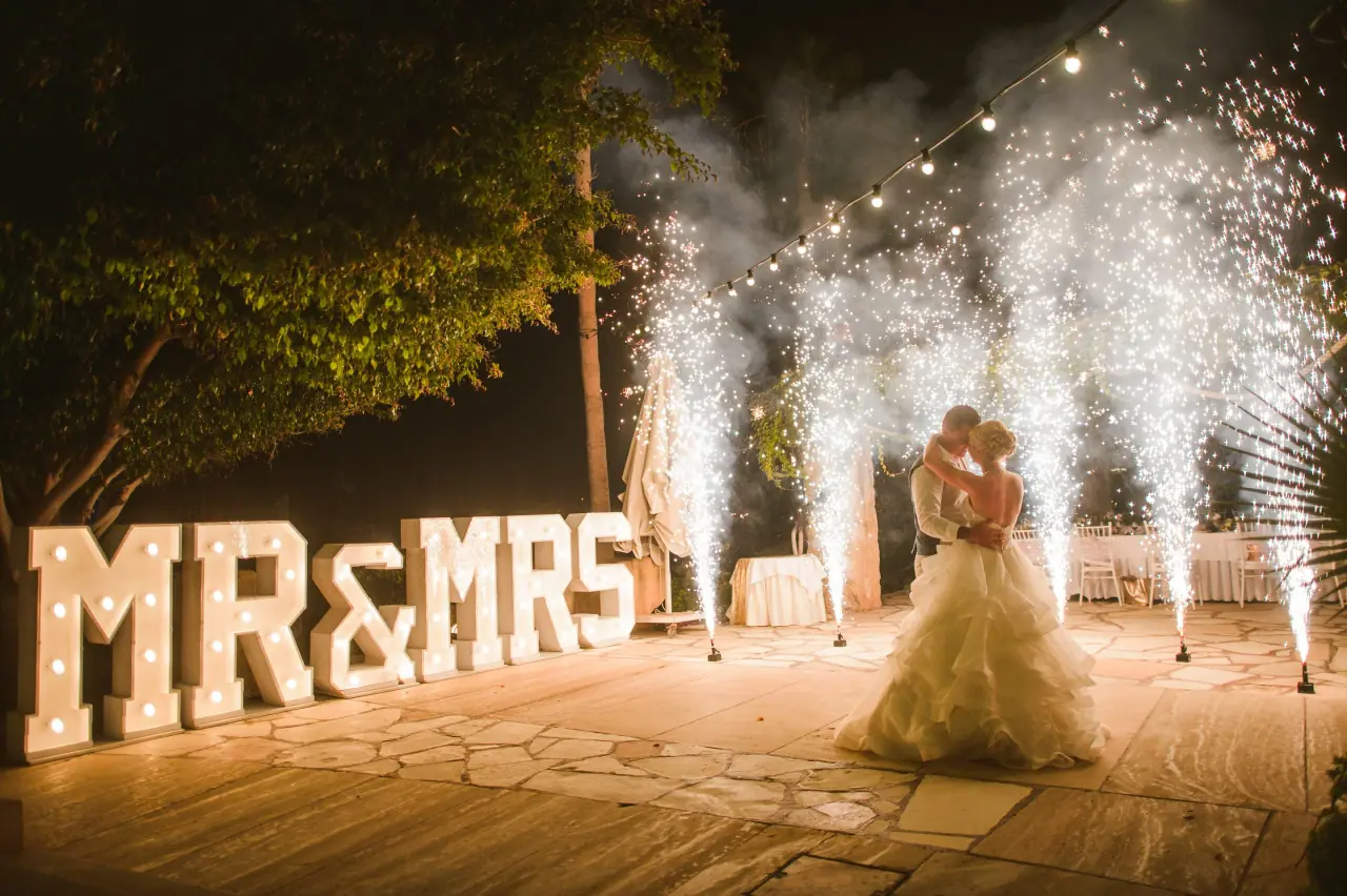 Charlotte and Nathan dancing beside sparkler fountains and a lit Mr & Mrs sign at Coral Beach Hotel, Paphos
