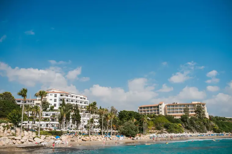 Coral Beach Hotel and its shoreline seen across turquoise water near Paphos