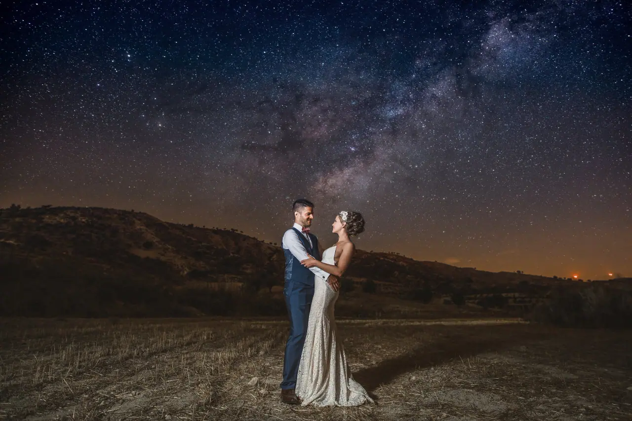 Bride and groom embracing in a field beneath the Milky Way at Vasilias Nikoklis Inn, Paphos