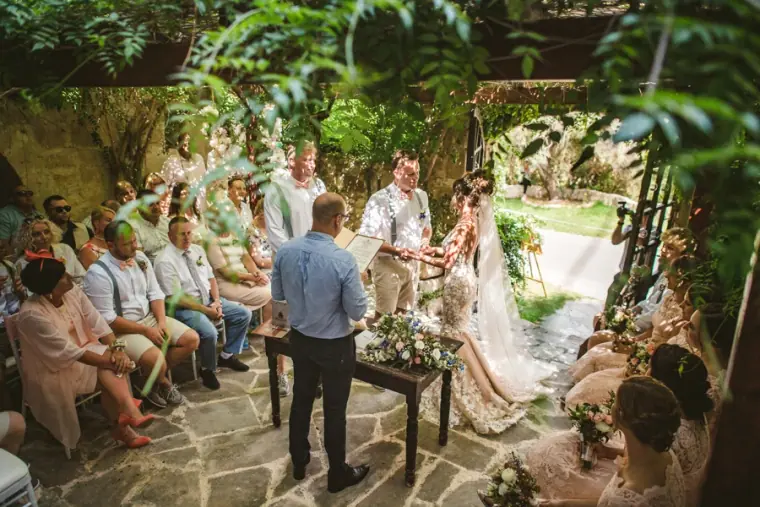 Guests watching Amie and Graeme's outdoor ceremony in the leafy courtyard