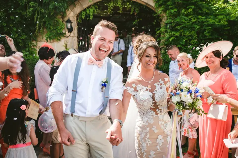 Amie and Graeme laughing as guests shower them with confetti