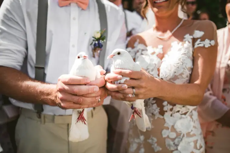 Amie and Graeme each holding a white dove ready for release