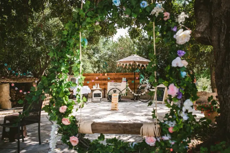 Rustic garden reception terrace framed by greenery and pink roses
