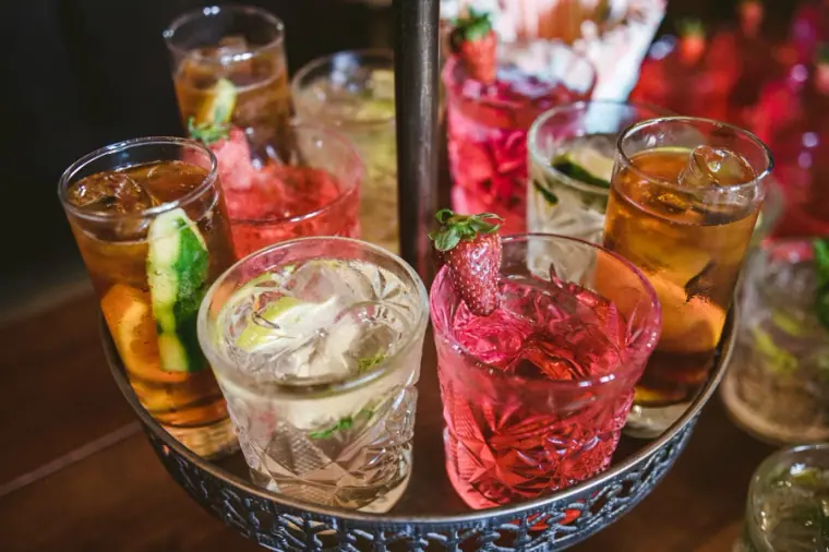 Tray of colourful cocktails and gin and tonics with fruit garnishes
