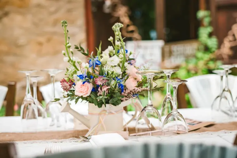 Reception table with a jug of wild flowers, glasses and lace runner