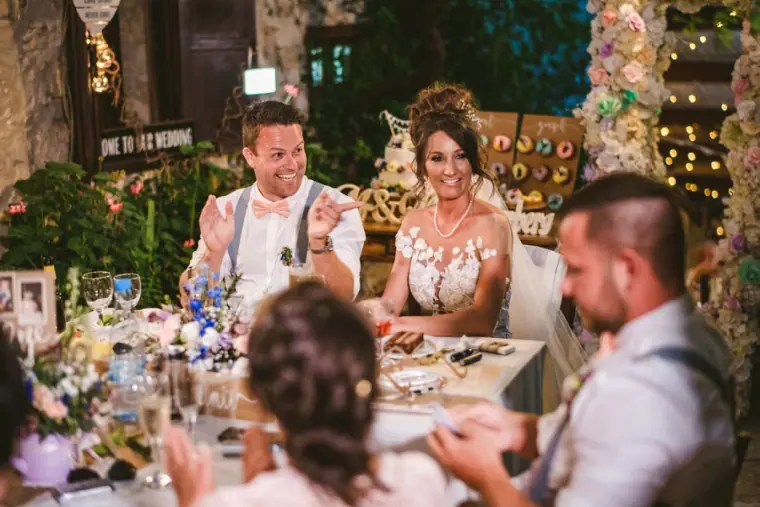 Amie and Graeme laughing at the top table as a groomsman speaks