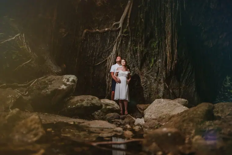 Kim and Craig dwarfed by gnarled tree roots and boulders in an Akamas gorge, Cyprus