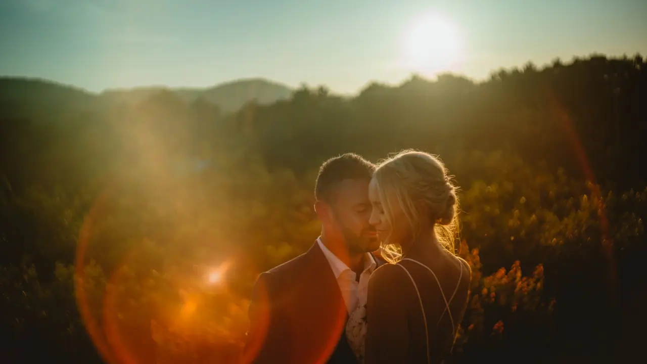 Sophie and Iain sharing a tender moment at sunset with sun flare over the hills, Can Gall, Ibiza
