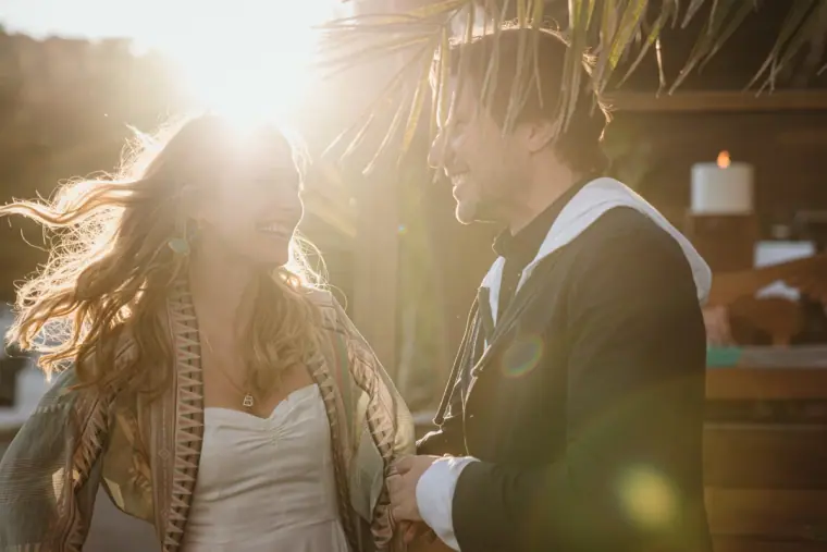 Antonia and Birger with windswept hair laughing together in bright backlight, Ibiza