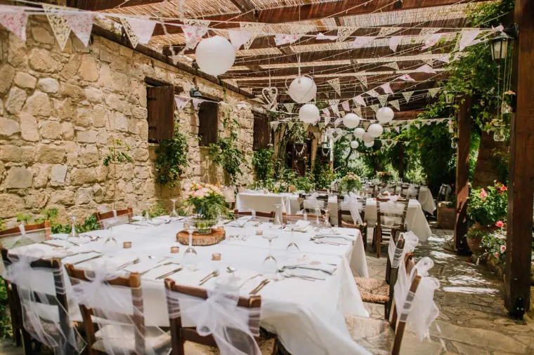 Rustic pergola reception dressed with bunting and greenery at Vasilias Nikoklis Inn, Paphos