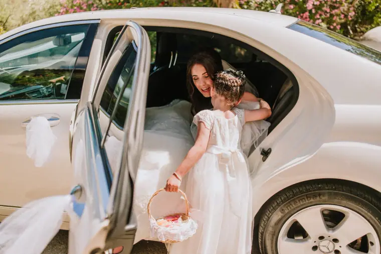 Flower girl with a basket helping Claire out of the wedding car