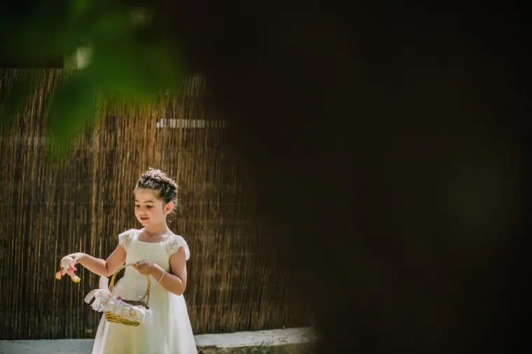 Flower girl scattering petals as she walks down the aisle