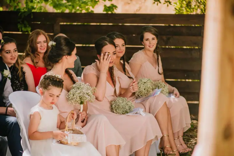 Bridesmaids and flower girl wiping away tears during the ceremony