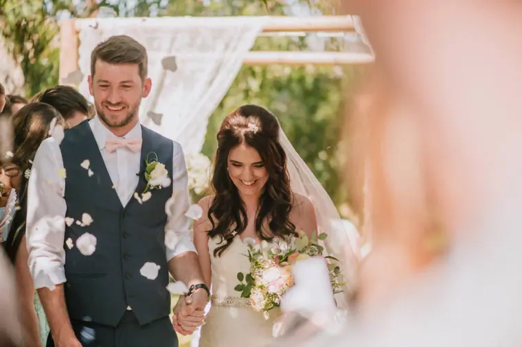 Sean and Claire walking back down the aisle through falling petals