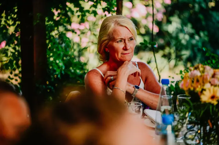 Guest resting her chin on her hand, listening to the speeches