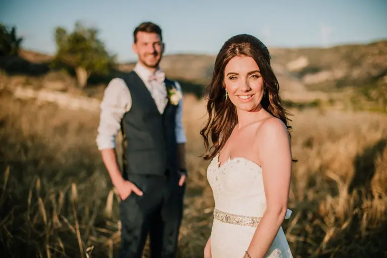 Claire smiling over her shoulder as Sean watches her in the golden field