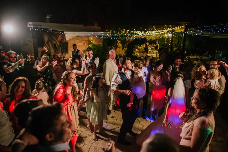 Packed dance floor at night beneath strings of fairy lights