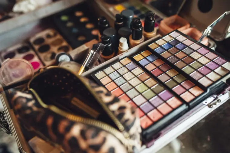 Open make-up palette and leopard-print bag on the dressing table