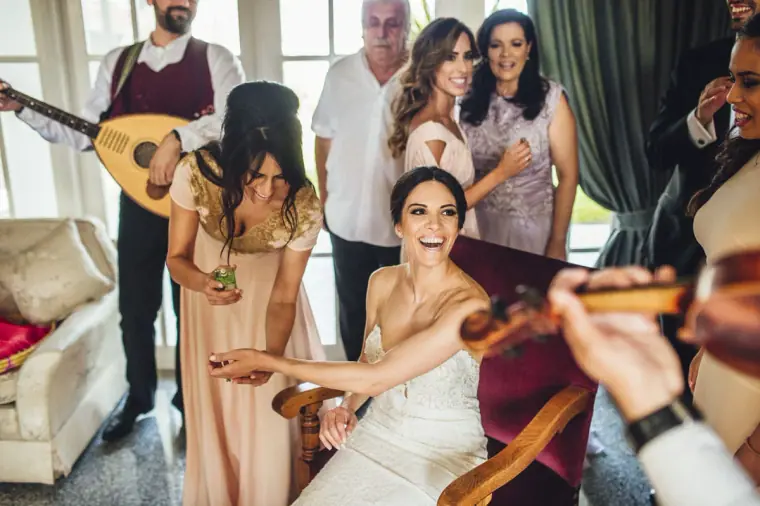 Ruby laughing in her chair surrounded by family and musicians