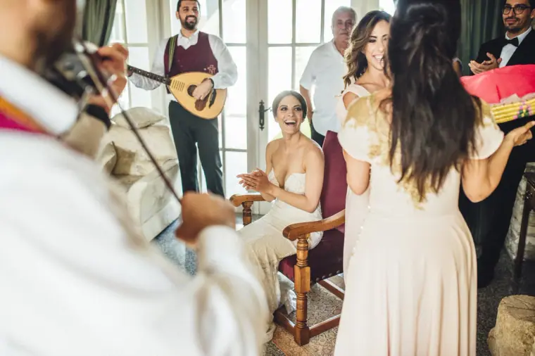 Musicians playing as women dance around Ruby in the living room