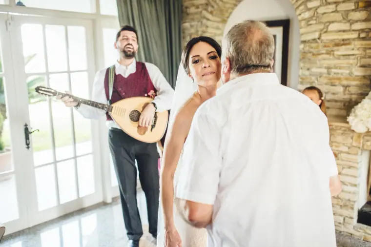 Relative wrapping a red scarf around Ruby as the lute player plays