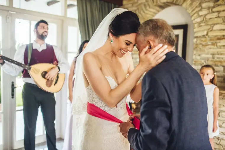 Ruby's father embracing her after tying the red sash around her waist