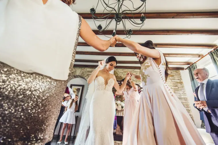 Ruby and her bridesmaids dancing beneath a chandelier