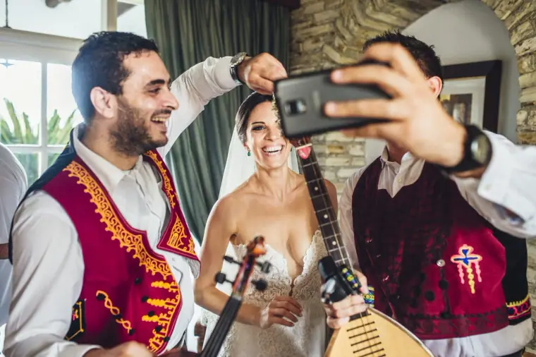 Ruby taking a selfie with the two traditional musicians in red waistcoats