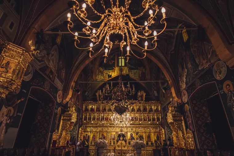 Ornate gilded church interior lit by a large chandelier
