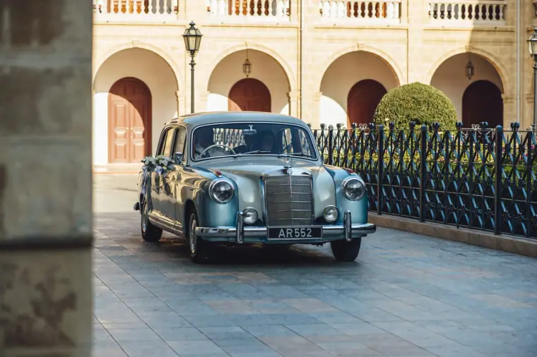 Classic grey Mercedes wedding car parked in the arcaded courtyard