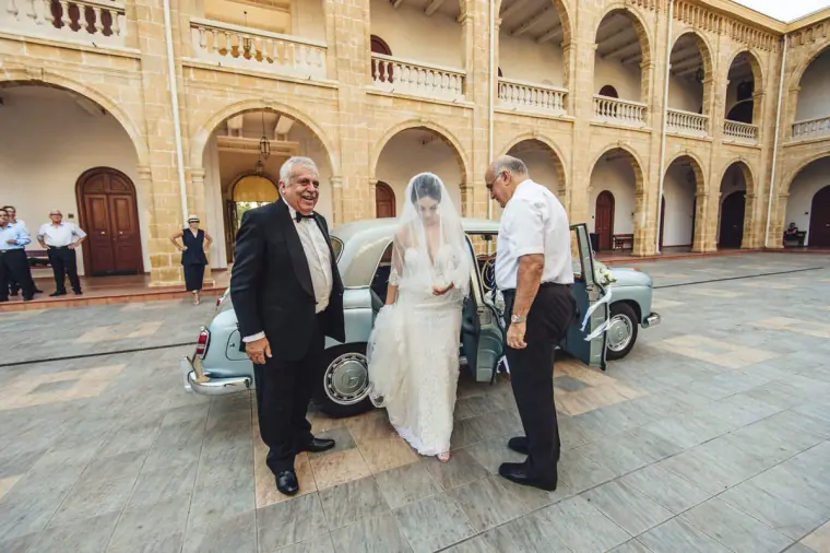 Ruby stepping out of the vintage car with her father in the courtyard