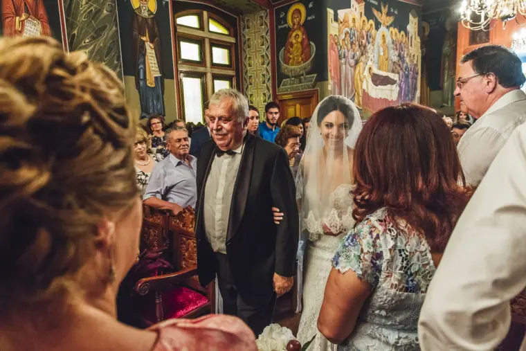 Ruby arriving at the front of the church with her father as guests watch