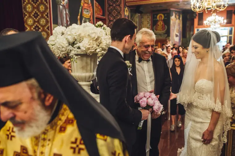 Ruby's father handing her to Angelos as the priest stands by