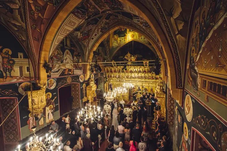Frescoed vaults and chandeliers above the crowded church during the service