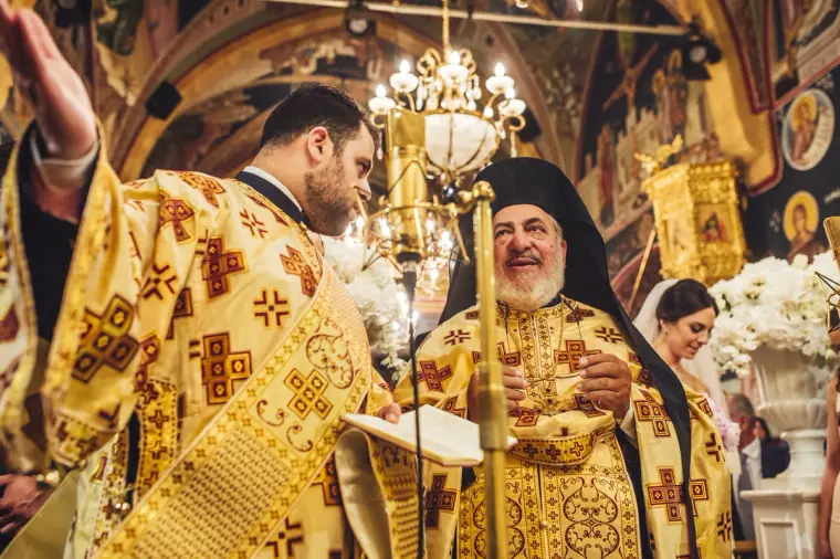 Priests in gold robes reading from the Gospel during the service
