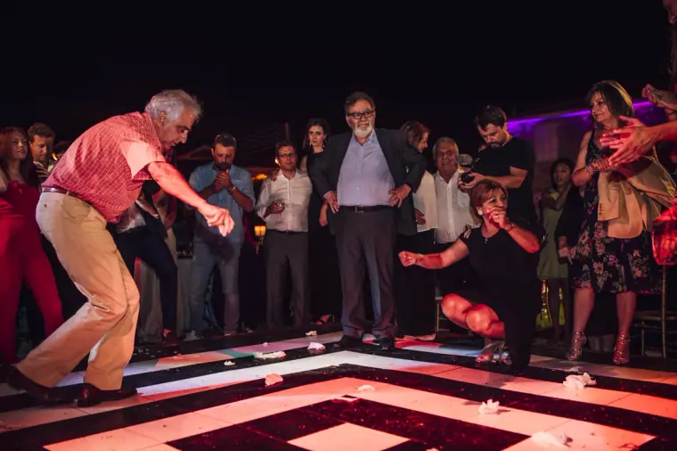 Older guest dancing energetically while the crowd watches