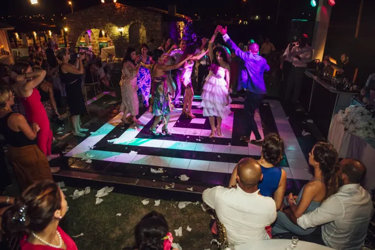Guests forming a dance line across the lit floor at the Nicosia reception