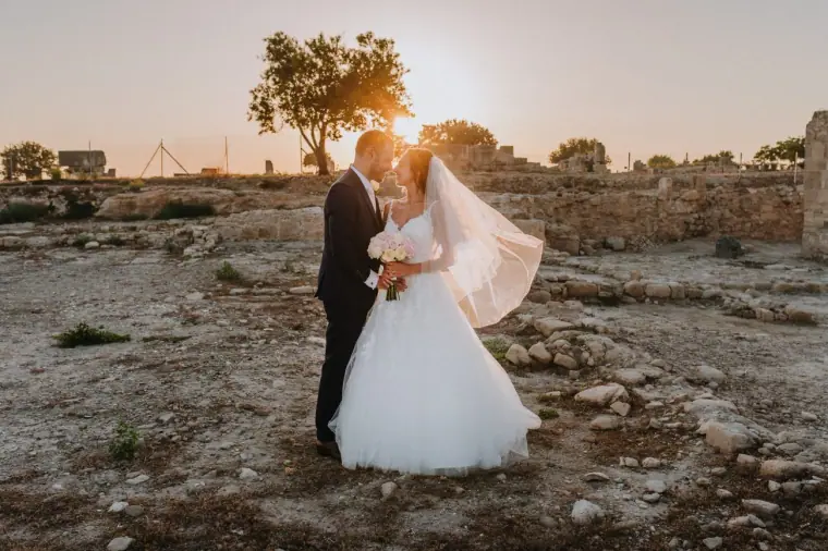 Marco and Anastassia kissing among sunlit ruins near Liopetro, Kouklia, her veil blowing in the wind