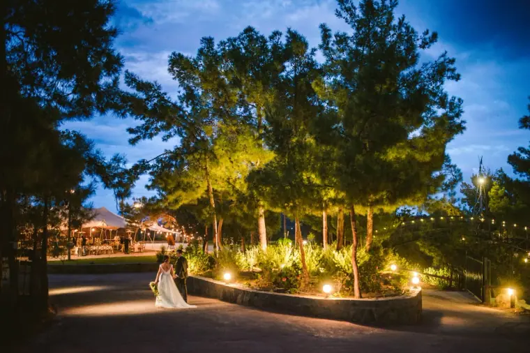 Lantern-lit garden paths and trees at dusk with the bride on the drive, Nermine and Chris at Lexeko Estate