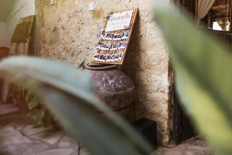 Seating plan propped against a rustic stone wall, glimpsed through leaves