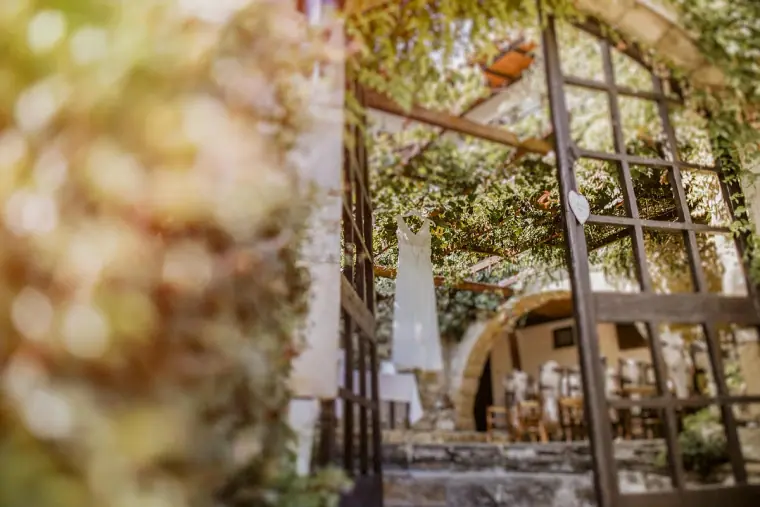 Vine-covered iron gate opening onto the ceremony courtyard at Vasilias Nikoklis Inn