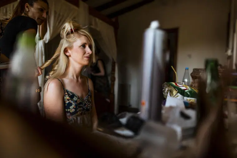 Bridesmaid with hair pinned up getting ready in a room at the inn