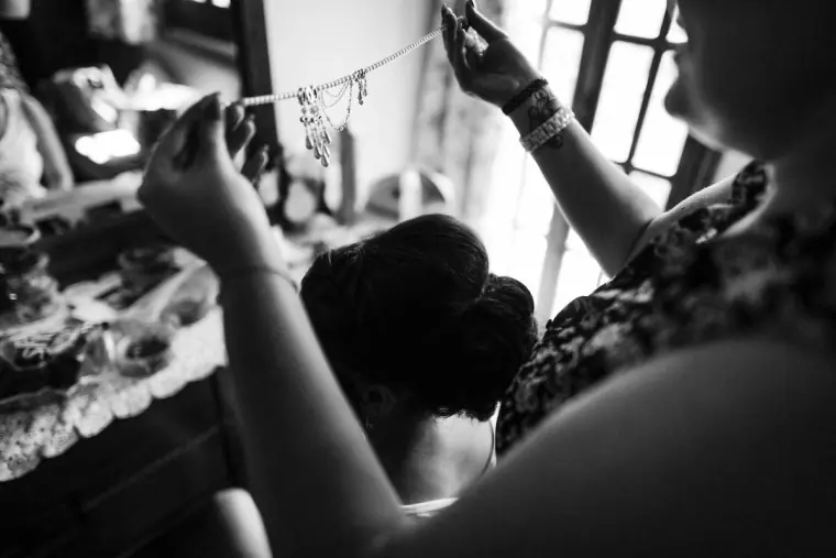 Black-and-white photo of the bride's headpiece being fastened in her hair