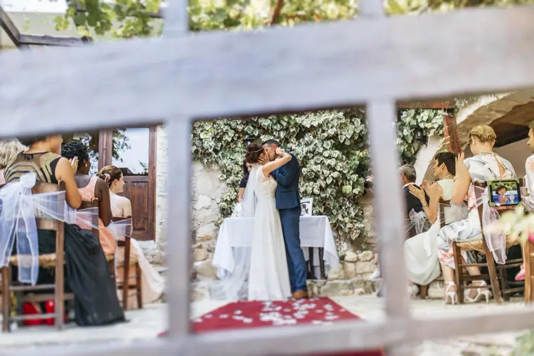 Byron and Donna's first kiss seen through a white window frame in the courtyard