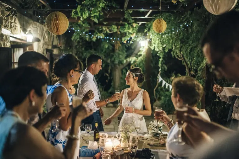 Bride and groom toasting with guests at the candlelit reception tables