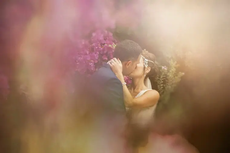 Donna and Byron kissing behind a soft blur of pink bougainvillea at Vasilias Nikoklis Inn, Paphos