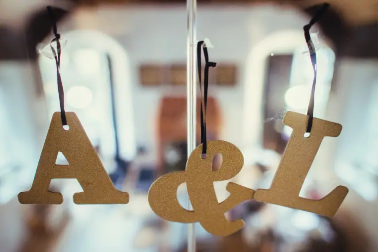 Wooden "A & L" initials hanging on ribbons in the window