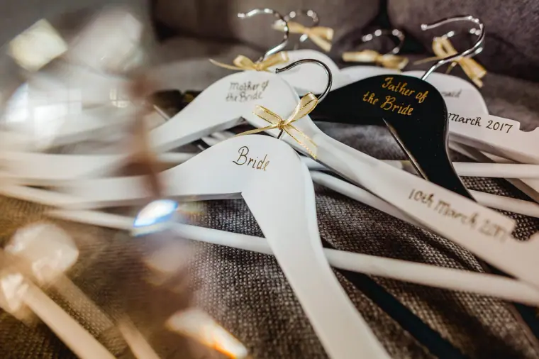 Close-up of hangers lettered "Bride" and "Mother of the Bride" with the wedding date